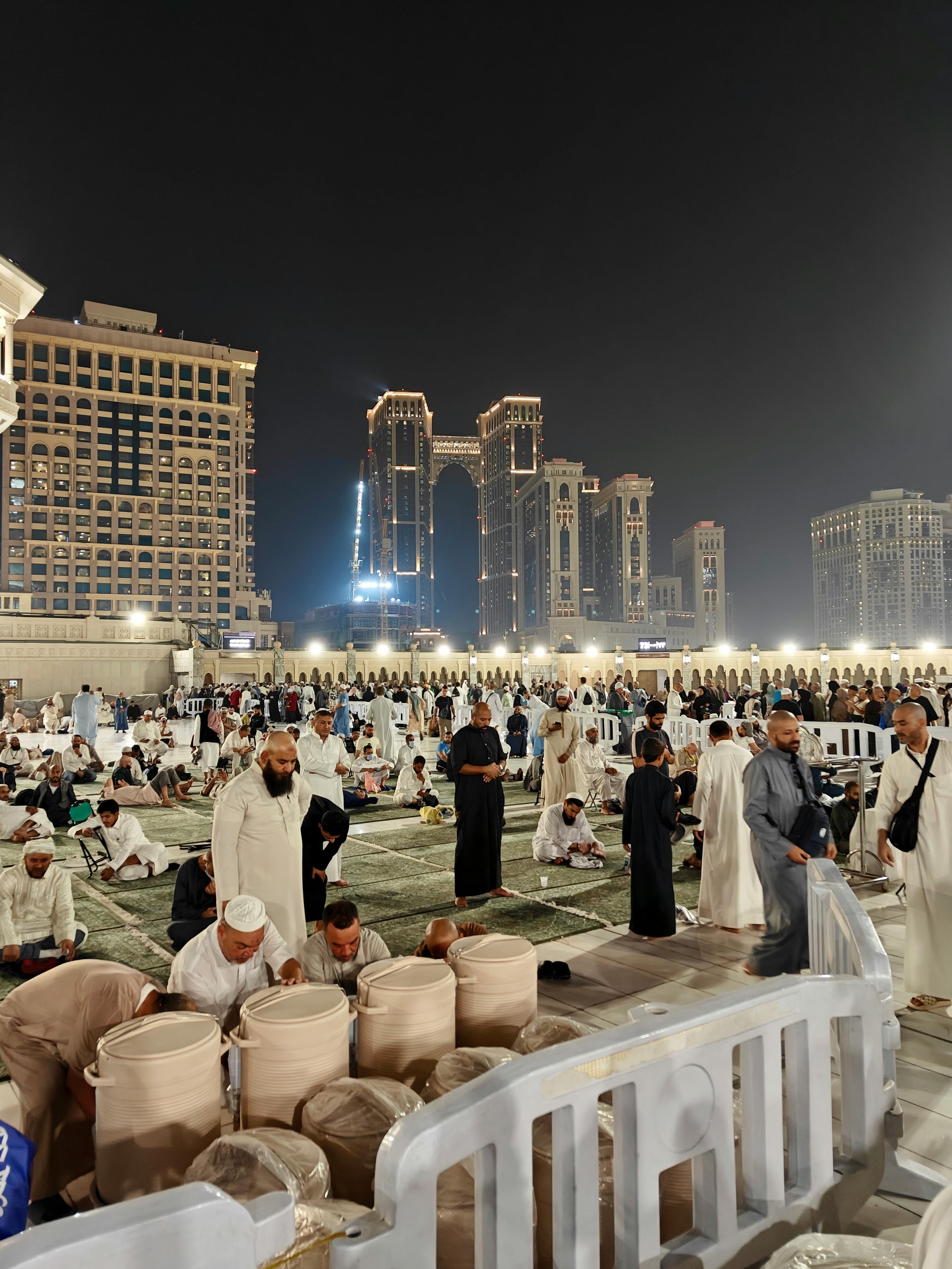 Pilgrims resting and praying near Masjid al-Haram at night